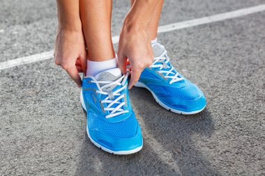 tatlı genç kadın spor ayakkabı bağlama
