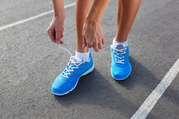 Primo piano della giovane donna che lega scarpe sportive — Foto Stock