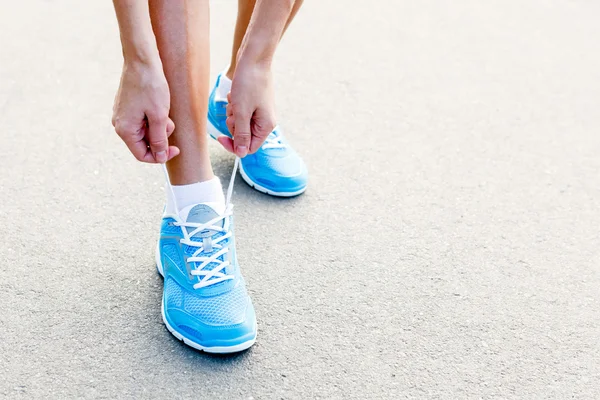 Primo piano della giovane donna che lega scarpe sportive — Foto Stock