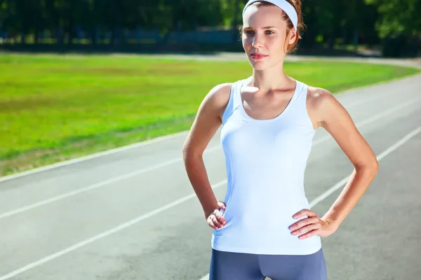 Mujer joven en el estadio preparándose para correr maratón . — Foto de Stock