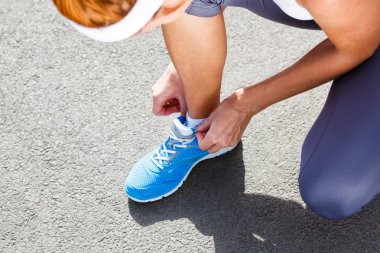 genç kadın spor ayakkabı bağlama.