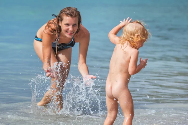 Mãe e bebê brincando na praia de verão . — Fotografia de Stock