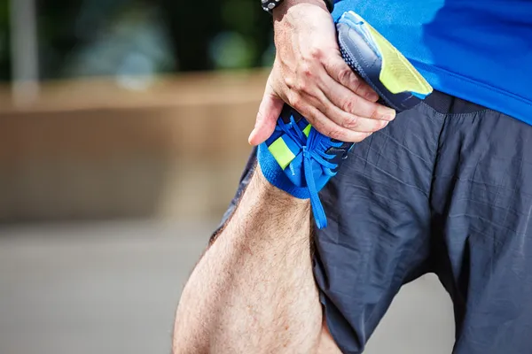 Homme coureur étirement avant l'entraînement . — Photo