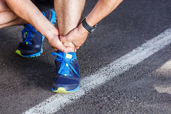 Gebrochener verdrehter Knöchel - Laufsportverletzung. männliche Läuferin touchin — Stockfoto