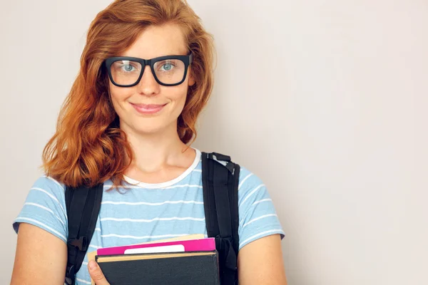 Portret van jonge slimme student met boeken permanent. — Stockfoto