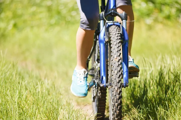 Closeup vrouw paardrijden mountainbike buitenshuis. — Stockfoto