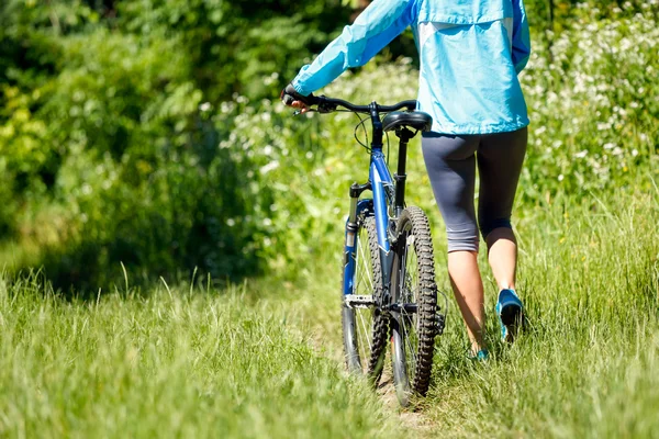 Mujer joven con bicicleta de montaña al aire libre . — Foto de Stock