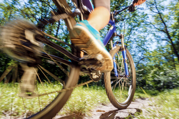 Young woman on mountain bike fast ride outdoors.