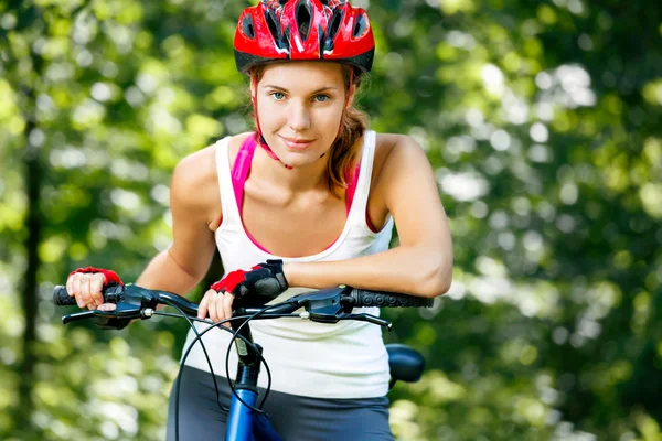 Счастливая молодая женщина наклонилась над рулем своего велосипеда . — стоковое фото