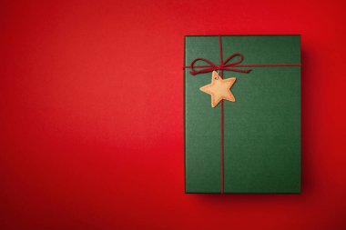 Kırmızı arkaplanda yeşil hediye veya Noel kutusu.