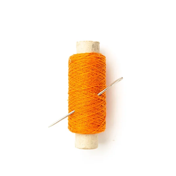 白い背景に隔離された針でオレンジ色の糸のスプール — ストック写真