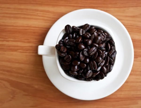 Kaffebönor med vit kaffekopp . — Stockfoto