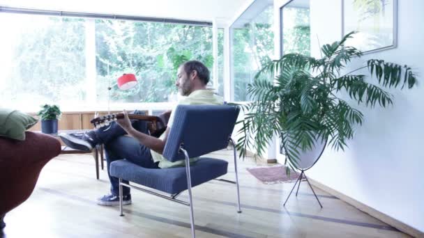 Homem tocando guitarra e relaxando em casa — Vídeo de Stock