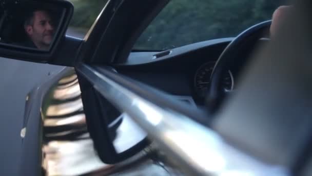 Чоловік сидить у машині на водійському сидінні — стокове відео