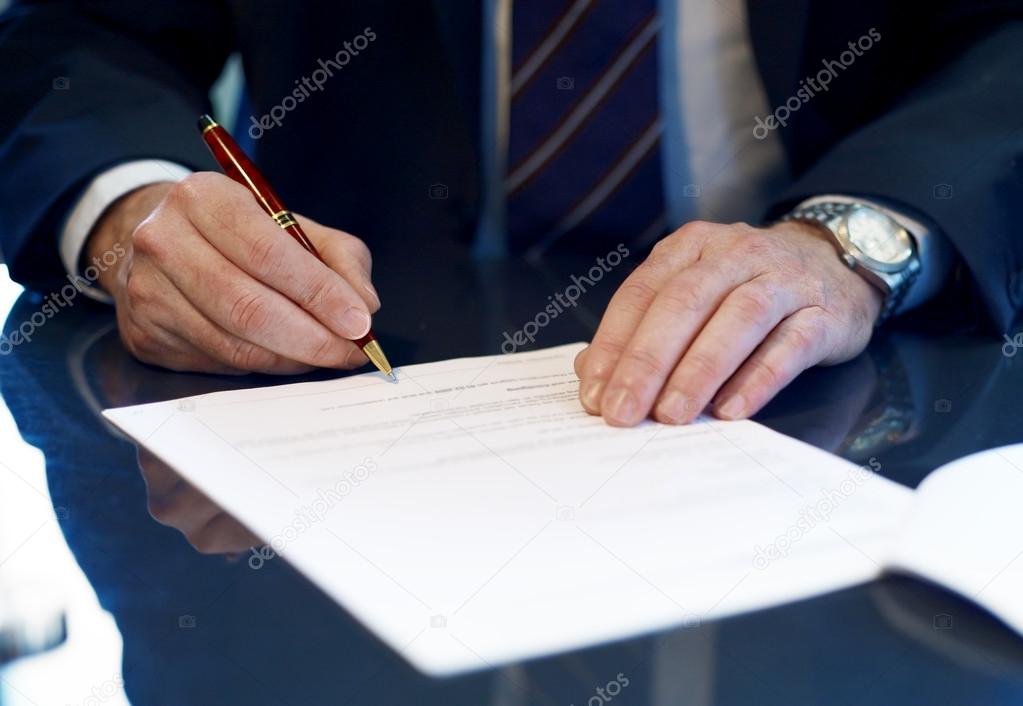 Close up of businessman signing a contract.