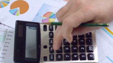 Belgeler ve hesap makinesiyle çalışan iş adamı