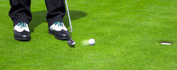 Golf green hole course man putting ball inside short putt