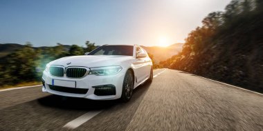 hızlı BMW M5 arabası İspanya 'da gün batımında manzara yolunda.