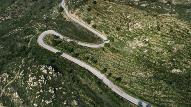 Güneşli bir yaz gününde ufka giden boş uzun dağ yolu. Parlak gün batımında..