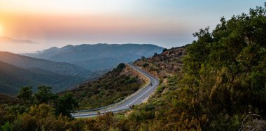 Güzel parlak güneş ışınları ile yaz aylarında dağlar ufuk içine Akdeniz deniz kıyısı yol - geniş açı panorama atış