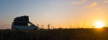 Taşıyıcı Kamp Minibüsü Kaliforniya Okyanusu kıyısındaki Doğada 