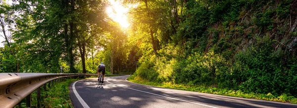 森の風景で丘に登るレースバイクで成熟した大人フランスの国の道路 — ストック写真