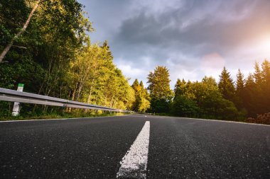 Baharda Sessiz Orman 'a giden otoban. Parlak güneş ışınları altında. Gizemli içerik için kopyalama alanı.