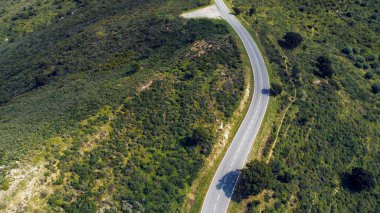 Güneşli bir yaz gününde, gün batımında ufka giden boş uzun dağ yolu.