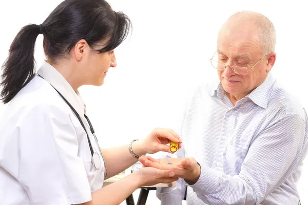 Doutor dando o remédio para um homem idoso — Fotografia de Stock