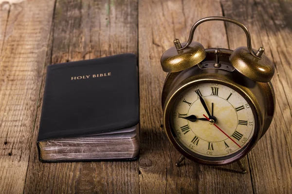 Bible with clock on wood — Stock Photo, Image