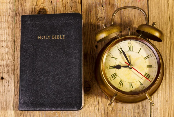 Bible with clock on wood — Stock Photo, Image
