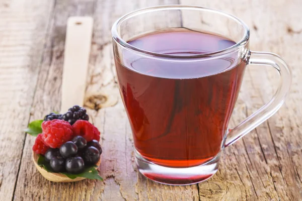 Vadon termő bogyósok, fakanállal piros gyümölcs tea — Stock Fotó