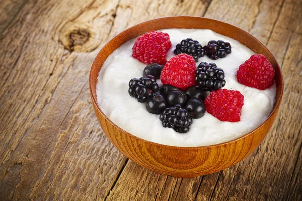 Yogurt with forest berries in wooden bowl — Stock Photo, Image