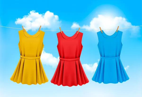 Conjunto de vestidos de colores colgando en un tendedero en un día soleado . — Vector de stock