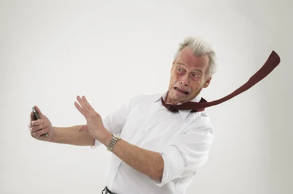 Businessman being battered by strong winds — Stock Photo, Image