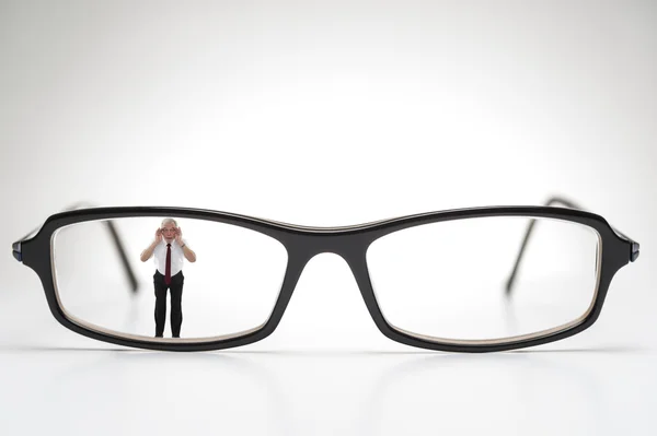 Diminutive elderly man peering through spectacles — Stock Photo, Image