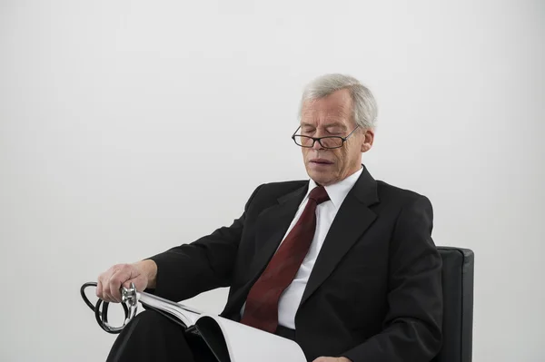 Elderly physician reading a medical journal — Stock Photo, Image