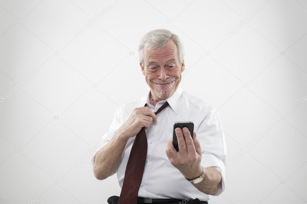 Senior man smiling at a mobile phone