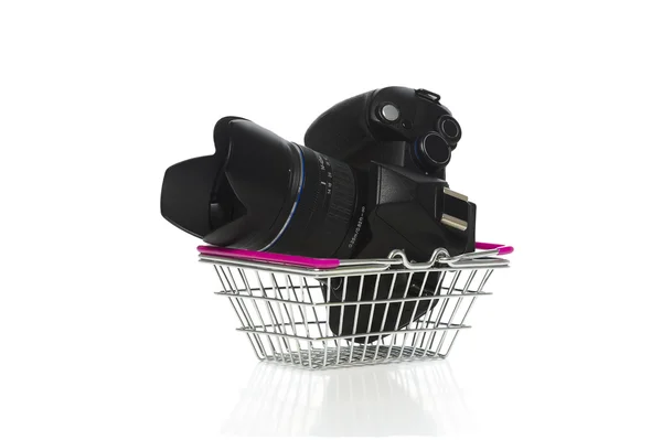 Camera and lens in a shopping basket — Stock Photo, Image