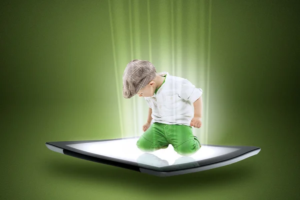 Little boy on a tablet with beams of data — Stock Photo, Image