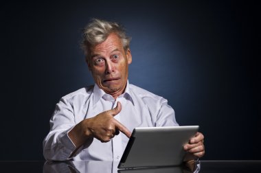 Man pointing to his laptop in horror and disbelief clipart