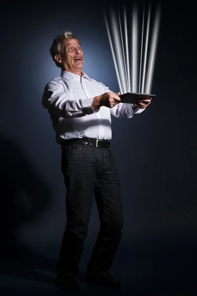 Geschäftsmann hält ein Tablet in der Hand, das Licht ausstrahlt — Stockfoto