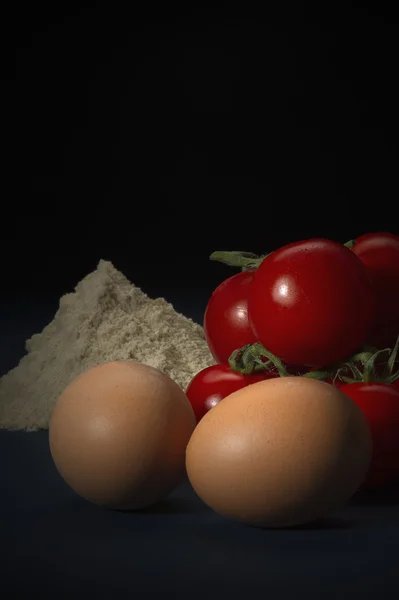 Ovos, farinha e tomate cereja fresco maduro — Fotografia de Stock