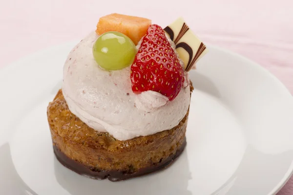 Mini cake topped with creamy mousse and fruit — Stock Photo, Image