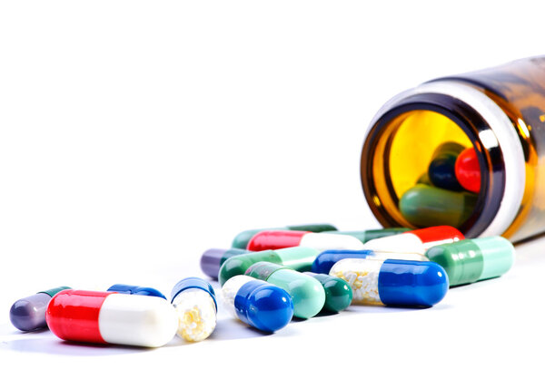 Pills an pill bottle on white background