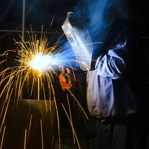 带保护面罩的焊机,焊接金属和火花 — 图库照片