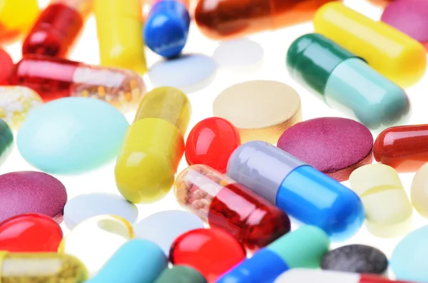 Muchas píldoras de colores aislados en blanco —  Fotos de Stock