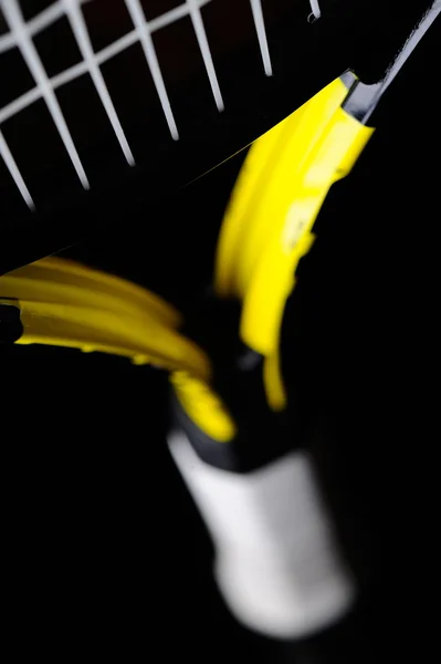 Raquete de tênis amarelo isolado fundo preto — Fotografia de Stock