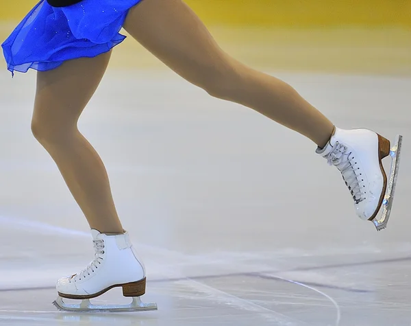 Pernas de mulher em patins de gelo brancos — Fotografia de Stock