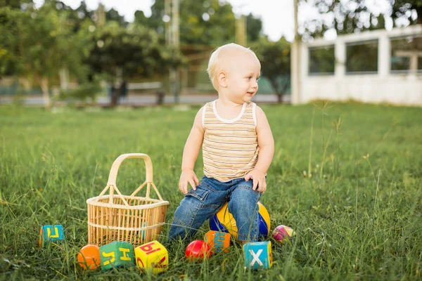 Niño jugando en un césped verde — Foto de Stock